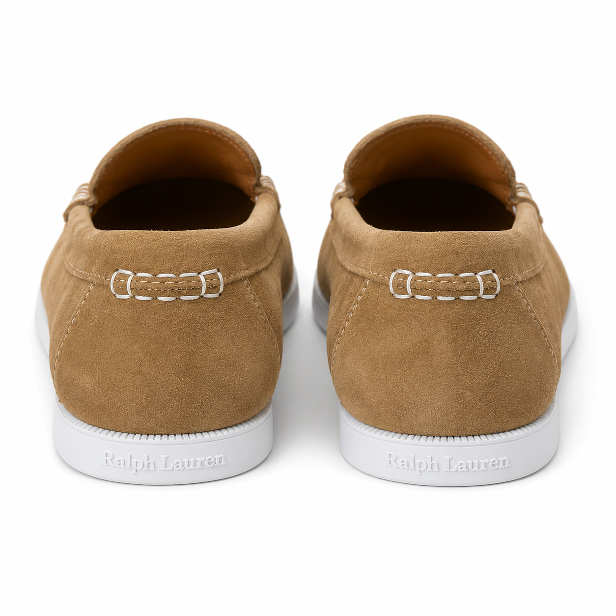 A pair of Ralph Lauren suede slip-on sneakers shown from the back, featuring a tan suede upper, white stitching, and a white rubber sole with the brand name debossed.