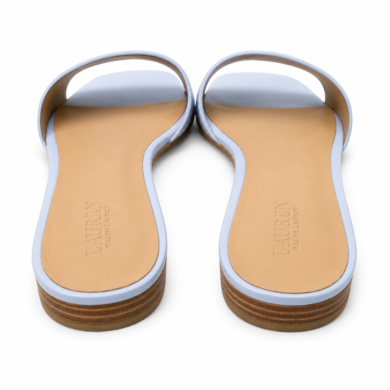 A pair of Lauren Ralph Lauren slide sandals shown from the bottom, featuring light blue uppers and tan insoles on a white background.