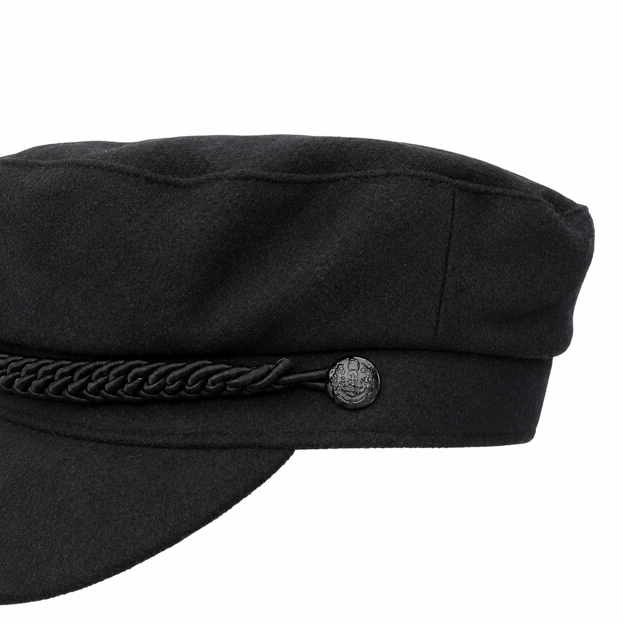 Close-up of a black wool-style cap with a braided black cord detail and a small round metallic emblem on the side, shown against a white background.