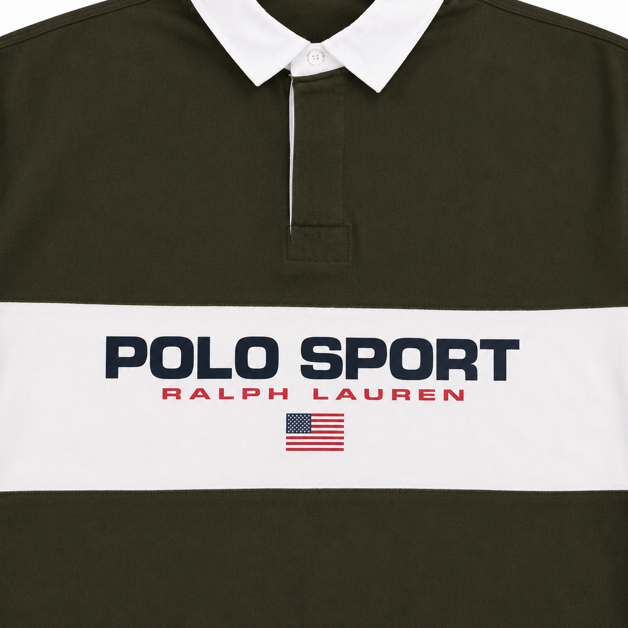 Close-up of a Polo Sport Ralph Lauren rugby shirt in dark olive green with a white collar and a wide white chest stripe featuring navy and red branding text and a small American flag.