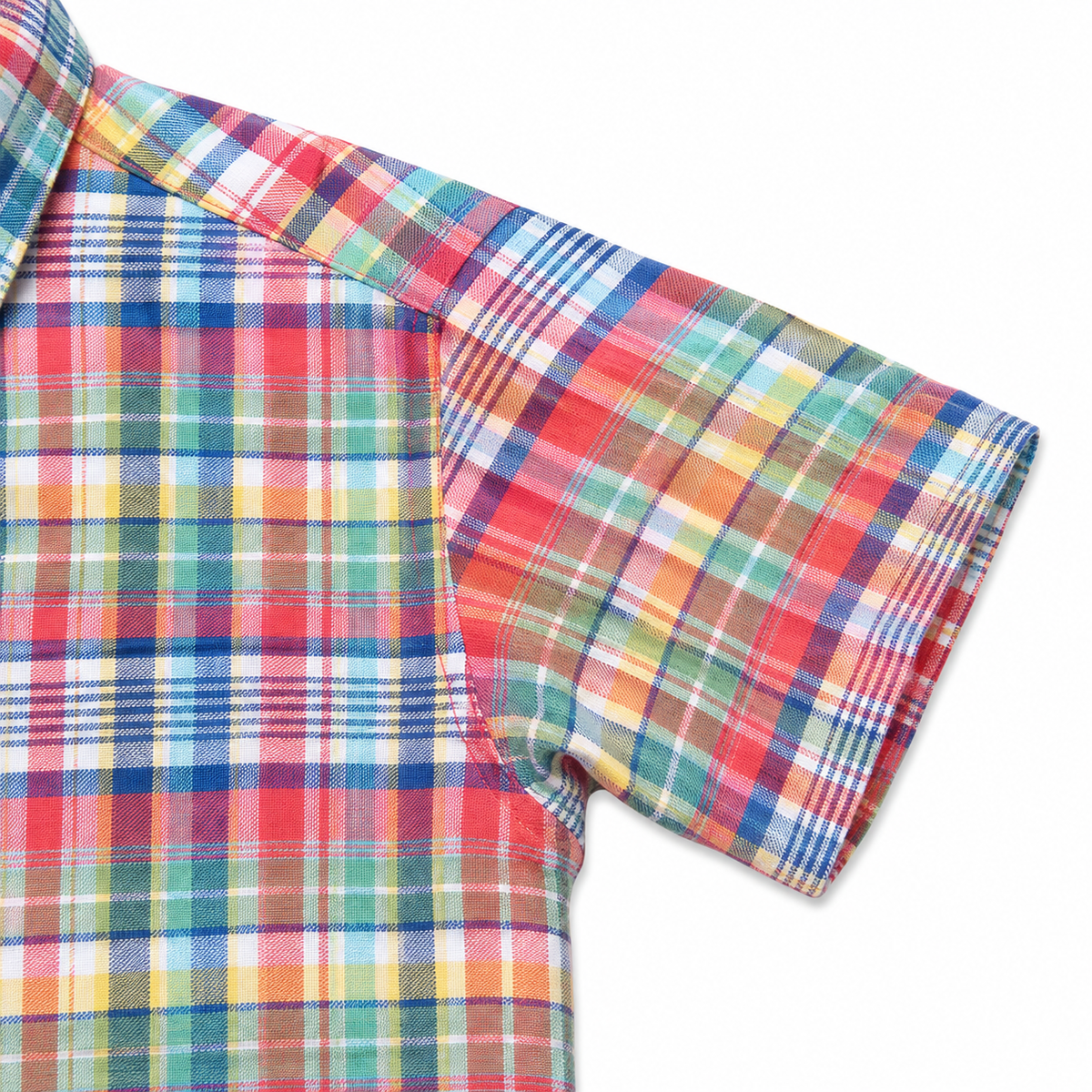 Close-up of a short-sleeve plaid shirt showing the colorful pattern on the body and sleeve, with red, blue, green, yellow, and white stripes on a white background.