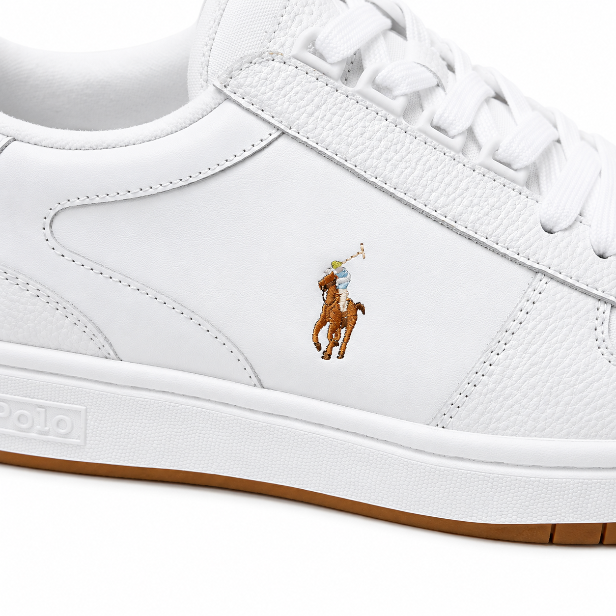 White leather Polo Ralph Lauren sneaker featuring the classic embroidered polo player logo on the side, white laces, and a white midsole with a brown gum outsole.