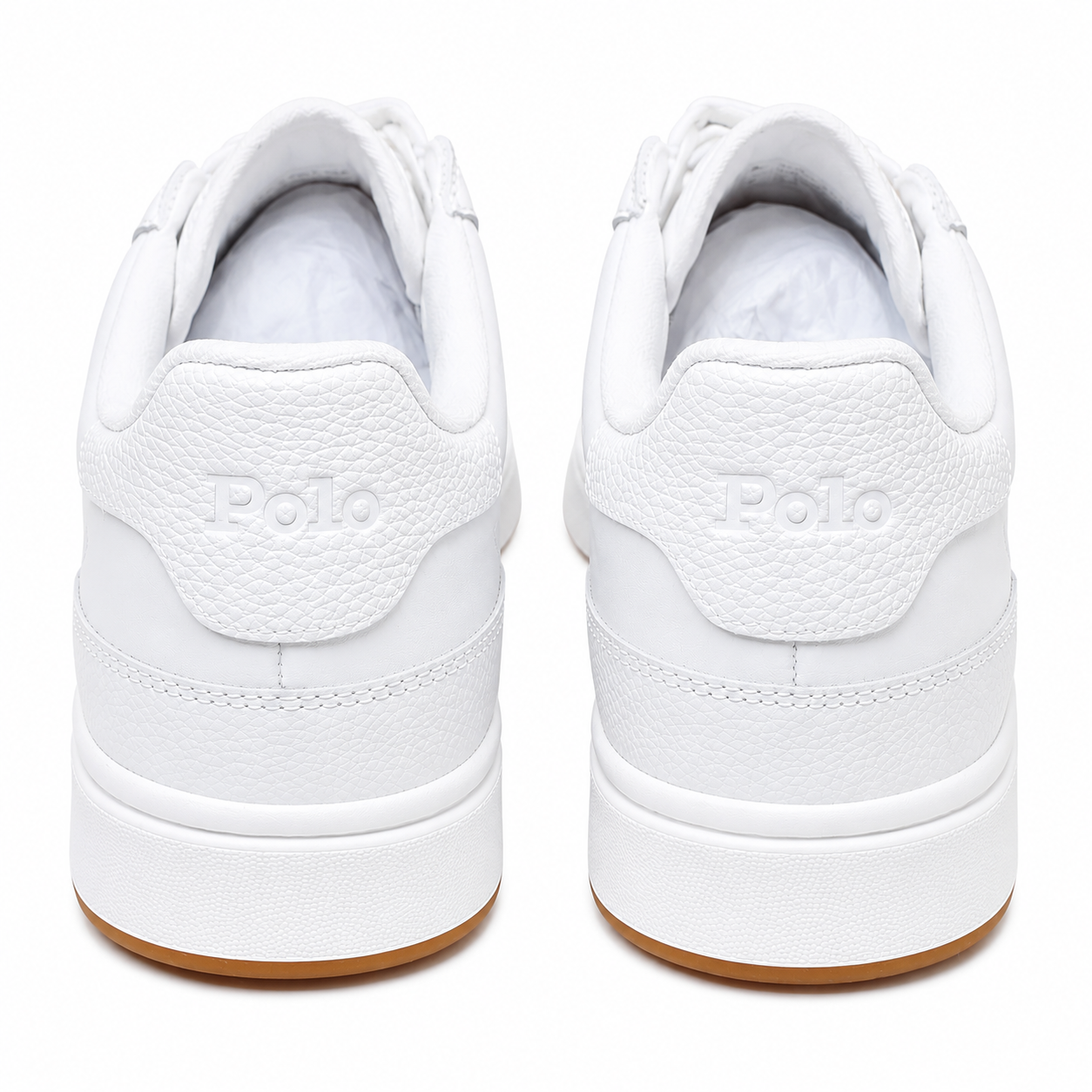 A pair of white Polo brand low-top sneakers shown from the back, featuring a textured white leather heel tab with the embossed Polo logo and a gum brown outsole.