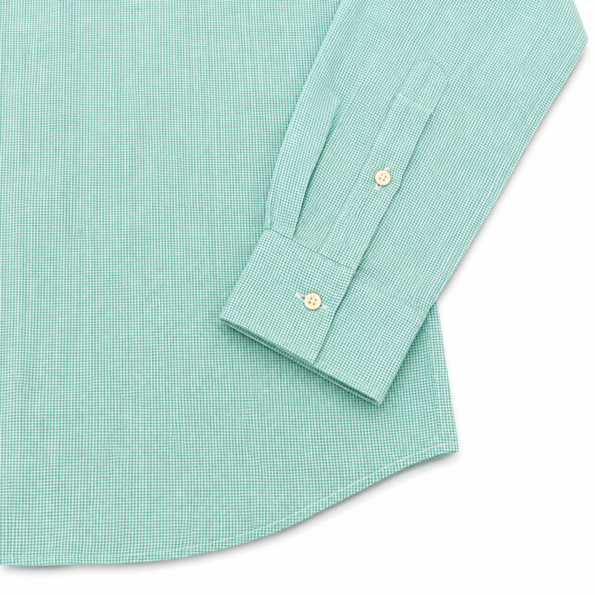 A close-up of a mint green and white micro-check patterned dress shirt, showing the fabric texture, a buttoned cuff, and decorative gold buttons on a white background.