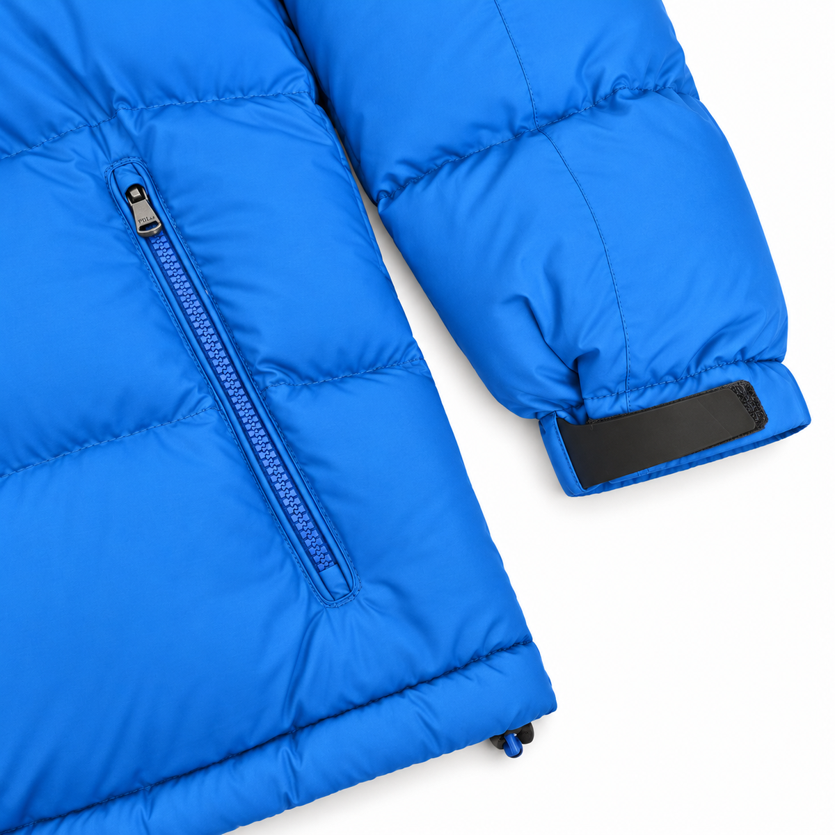 Close-up of a bright blue puffer jacket showing the sleeve cuff with a black elastic band and a zippered pocket on a white background.