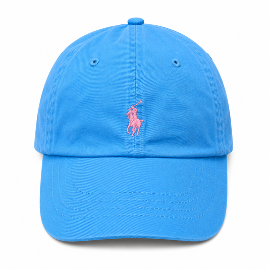 A bright blue cotton baseball cap featuring the classic pink embroidered Polo pony logo on the front, set against a plain white background.