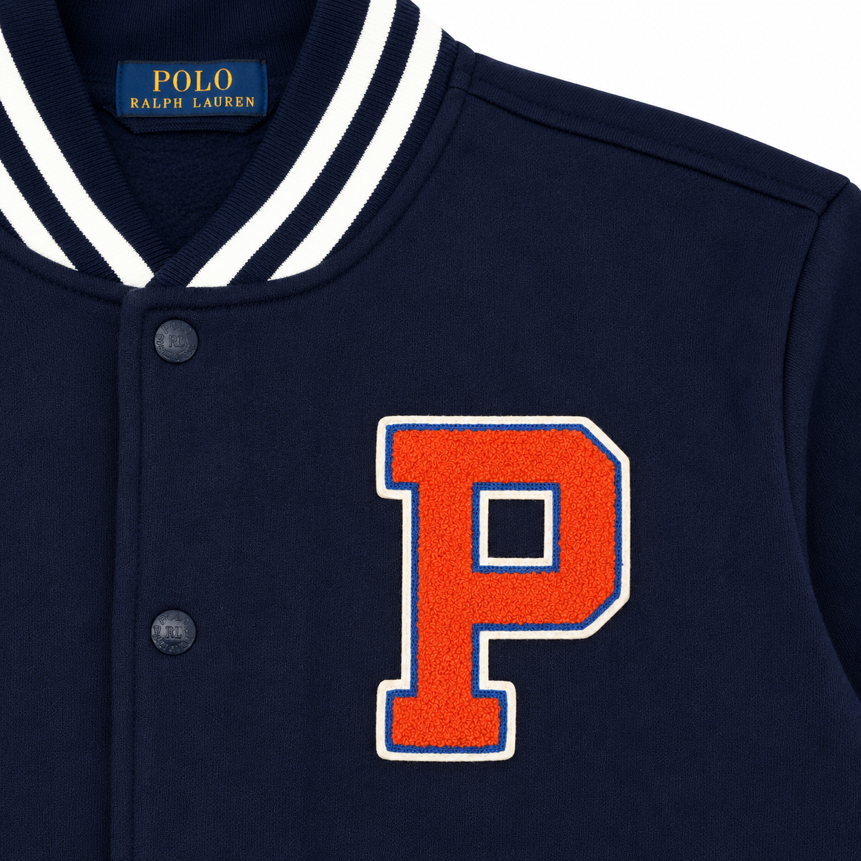 Close-up of a navy blue Polo Ralph Lauren varsity jacket featuring a large orange letter 'P' with white and blue trim on the chest, a white and navy striped ribbed collar, and dark buttons.