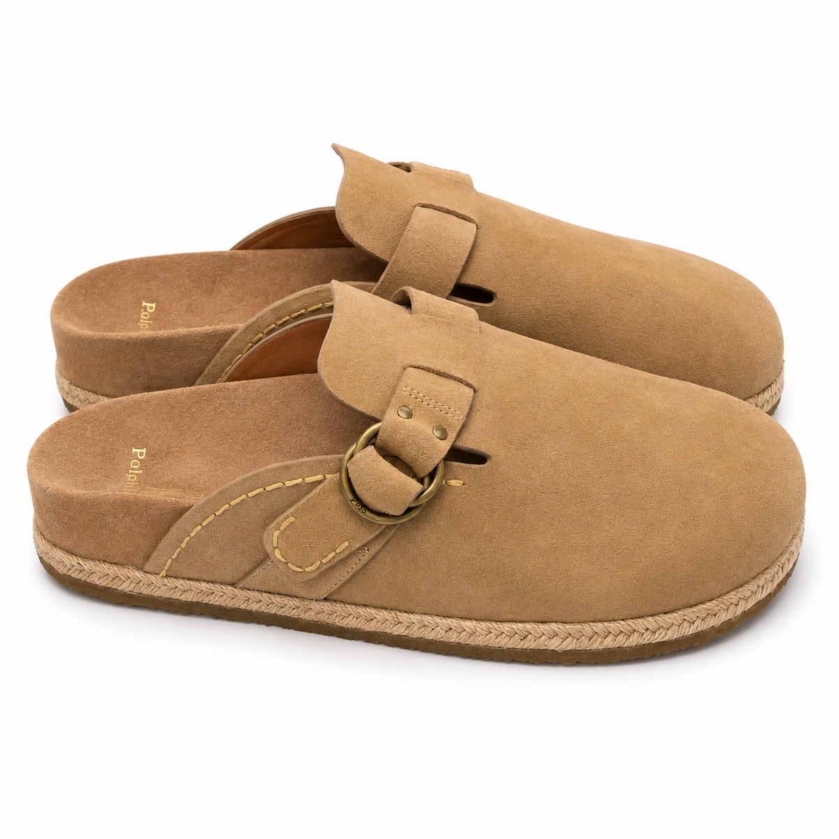 A pair of tan suede clogs with braided jute soles and brass-tone buckle straps, shown on a clean white background.