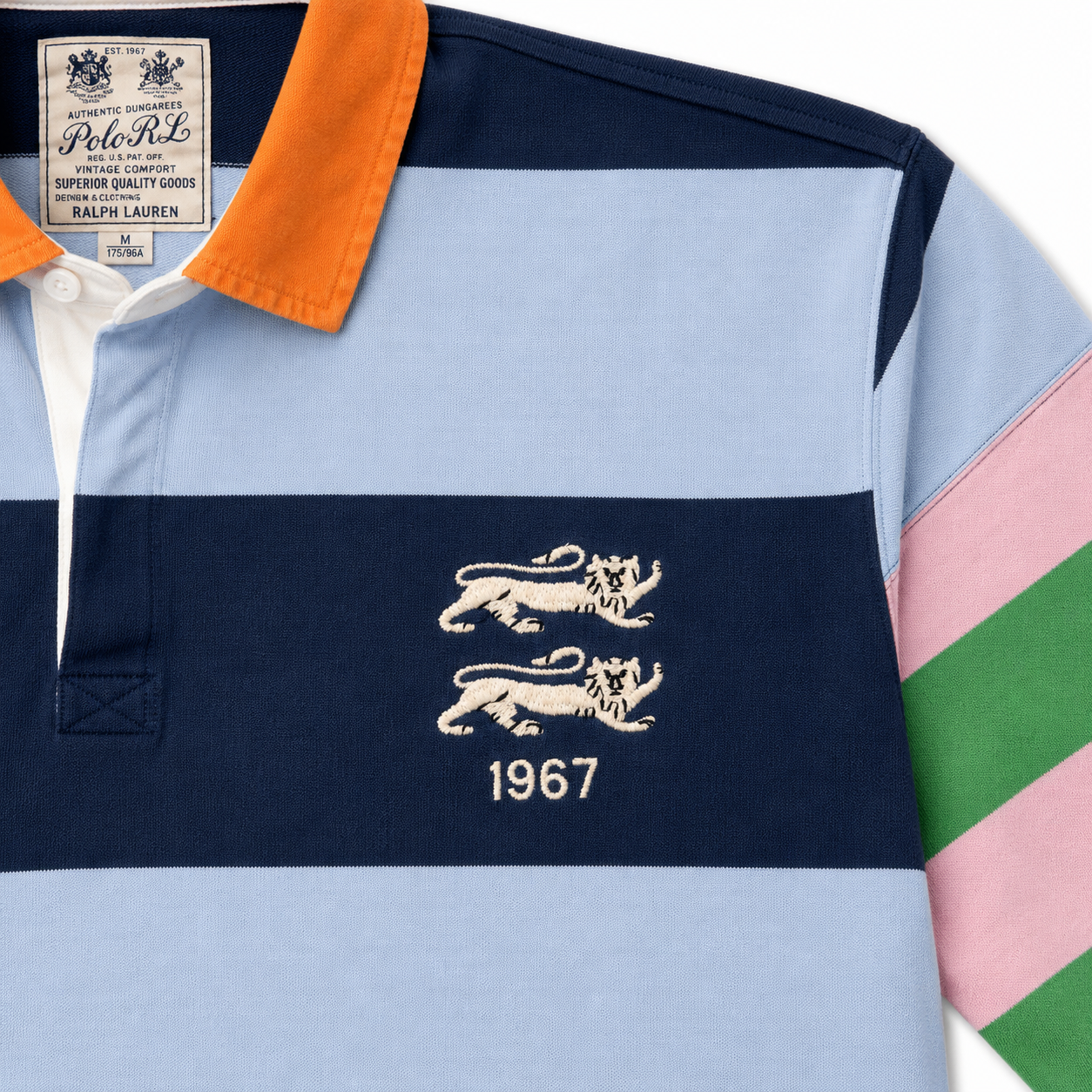A Polo Ralph Lauren rugby shirt in light blue, navy, and orange, featuring the embroidered double lion logo and '1967' on the chest.