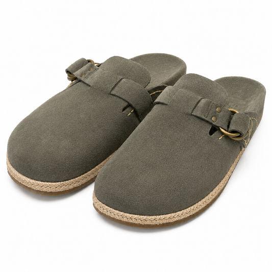 A pair of dark olive green clog-style mules with braided jute soles and brass-tone buckle details, shown on a clean white background.