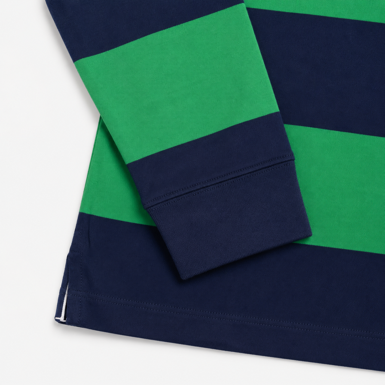 Close-up of a striped long-sleeve top with navy blue and bright green horizontal blocks, showing the folded cuff and hem on a white background.